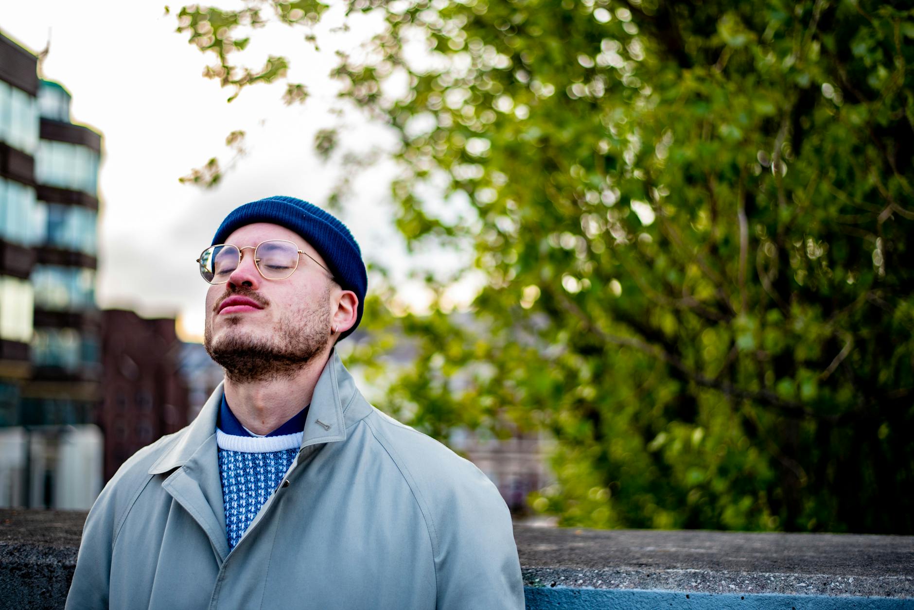 a man wearing a hat and glasses looking up